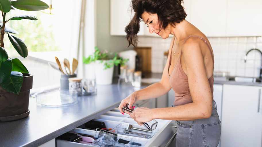 Woman cleaning kitchen drawers 